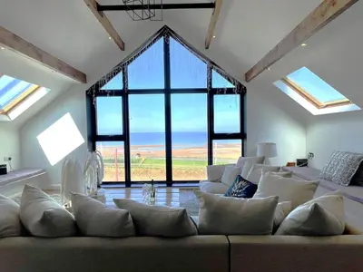 a living room with a large couch and large windows at Onyx House in Blackpool