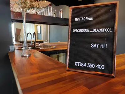 a sign on a wooden counter in a restaurant at Onyx House in Blackpool