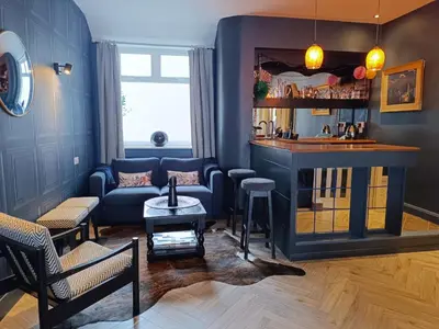 a living room with a couch and a bar at Onyx House in Blackpool