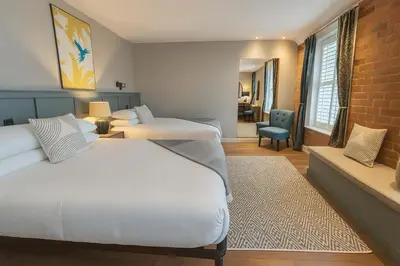 a hotel room with two beds and a chair at Onyx House in Blackpool