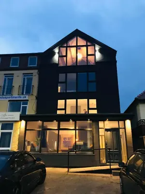 a black house with large windows in a parking lot at Onyx House in Blackpool