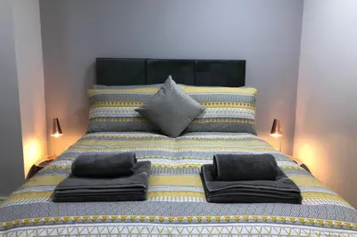 a large bed with pillows on top of it at Fishergate ApartHotel 1 - Stylish City Centre Apartment in Preston