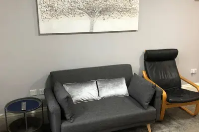 a living room with a couch and a chair at Fishergate ApartHotel 1 - Stylish City Centre Apartment in Preston