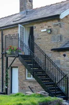 a brick house with a staircase leading to a door at Alpaca Fold in Preston