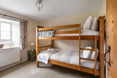 a bedroom with two bunk beds in a room at Maggie Puddle Cottage in Cartmel