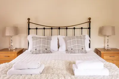 a bedroom with a bed with towels on it at Maggie Puddle Cottage in Cartmel