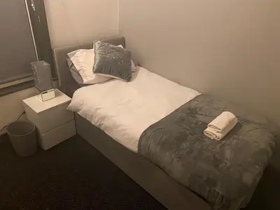a small bedroom with a bed and a night stand at Northern Pearl Hotel in Blackpool