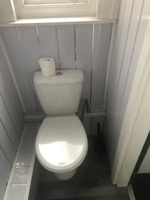 a white toilet in a bathroom with a window at Northern Pearl Hotel in Blackpool