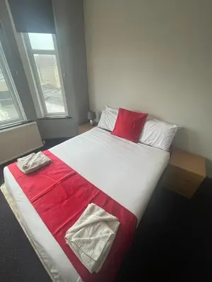 a bedroom with a large bed with a red blanket at Northern Pearl Hotel in Blackpool