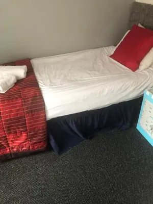 a bed with white sheets and red pillows on it at Northern Pearl Hotel in Blackpool