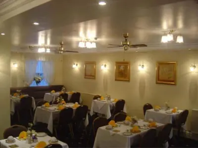 a dining room with tables and chairs with white table cloth at Gleneagles - Albert Road in Blackpool