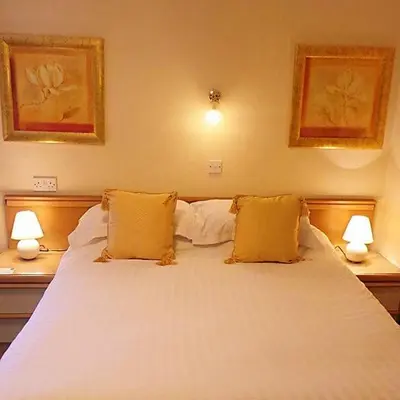 a bedroom with a large white bed with two lamps at Gleneagles - Albert Road in Blackpool