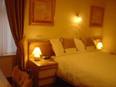 a bedroom with a bed and two lamps and a chair at Gleneagles - Albert Road in Blackpool
