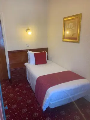 a hotel room with a bed and a picture on the wall at Gleneagles - Albert Road in Blackpool