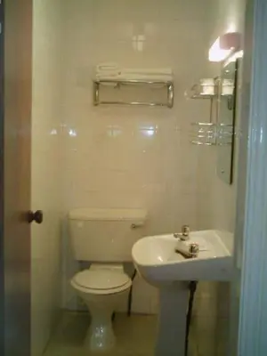 a white bathroom with a toilet and a sink at Gleneagles - Albert Road in Blackpool