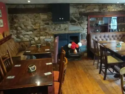 a restaurant with tables and chairs and a fireplace at The Engine Inn in Holker