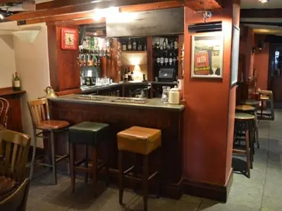 a bar in a restaurant with chairs and a counter at The Engine Inn in Holker