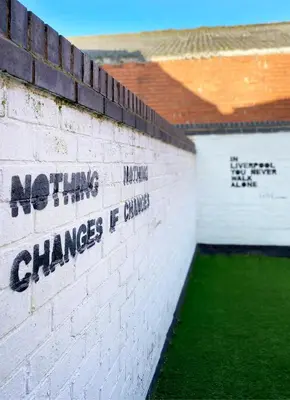 a brick wall with the words nothing changes unless changed at The Baltic Townhouses by Serviced Living Liverpool in Liverpool