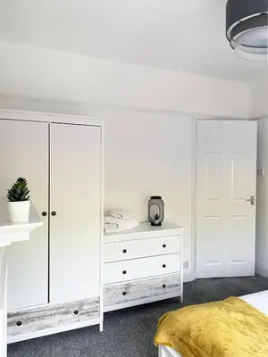 a white bedroom with a white dresser and a white closet at The Baltic Townhouses by Serviced Living Liverpool in Liverpool