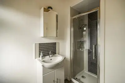 a white bathroom with a sink and a shower at Lakeview Lodge in Carnforth