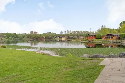 a view of a lake with houses in the background at Lakeview Lodge in Carnforth