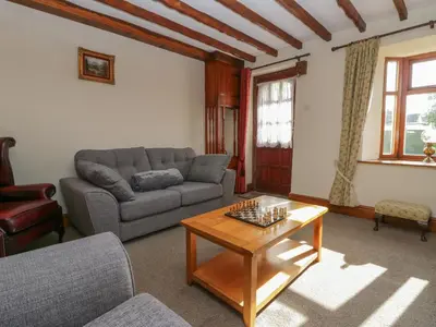 a living room with a couch and a table at Shipwreck Cottage in Millom