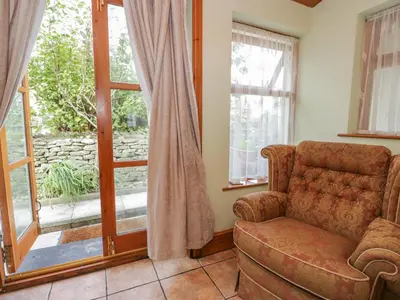 a living room with a couch and a window at Shipwreck Cottage in Millom