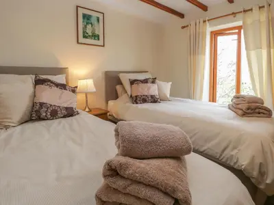a bedroom with two beds with towels on them at Shipwreck Cottage in Millom