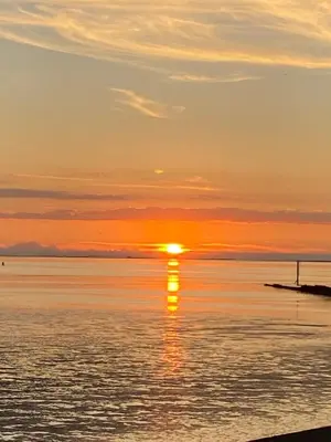 a sunset over the water with the sun setting at Nicks & Carmels by the sea in Heysham