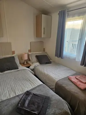 a bedroom with two beds and a window at Nicks & Carmels by the sea in Heysham