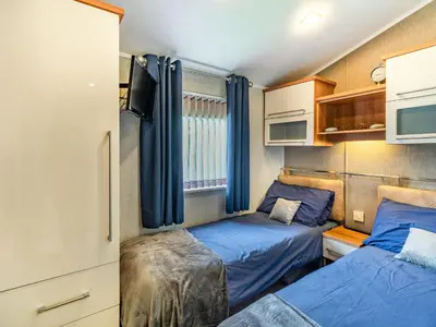 a small room with two beds in a caravan at Links Lodge in Grange Over Sands