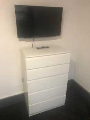a flat screen tv on top of a white dresser at Kirubash Central Pier Hotel in Blackpool