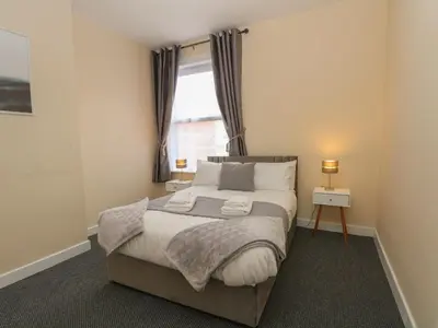 a bedroom with a large bed with a window at St Heliers in Blackpool