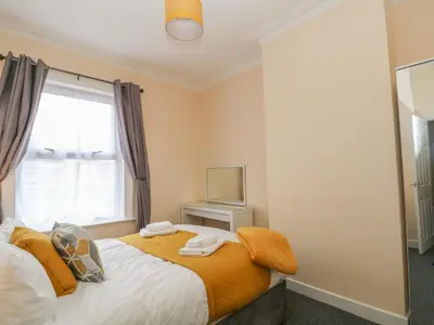 a bedroom with a bed and a window at St Heliers in Blackpool