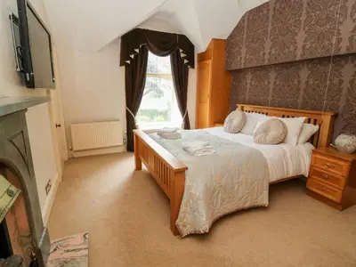 a bedroom with a large bed and a window at Manor House in Accrington