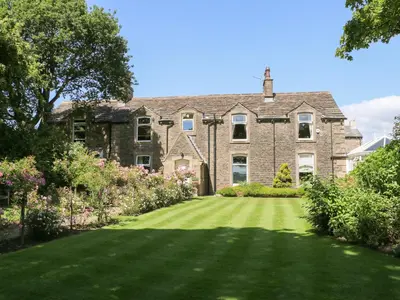 a large brick house with a green lawn at Manor House in Accrington