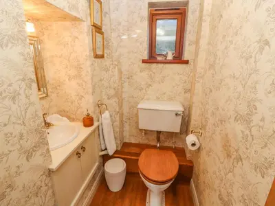 a small bathroom with a toilet and a sink at Clerk Beck Cottage in Ulverston