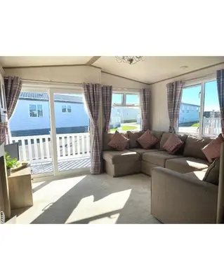a living room with a couch and some windows at 37 Bay View Oceans Edge by Waterside Holiday Lodges in Lancaster