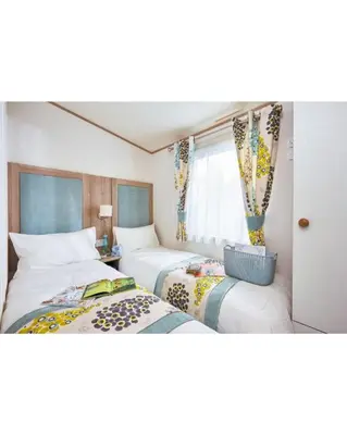 a bedroom with two beds and a window at 37 Bay View Oceans Edge by Waterside Holiday Lodges in Lancaster