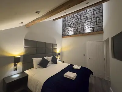 a bedroom with a bed with two towels on it at Edward Place Luxury Hot Tub Apartments in Blackpool