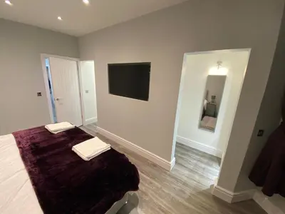 a bedroom with a bed and a flat screen tv at Edward Place Luxury Hot Tub Apartments in Blackpool
