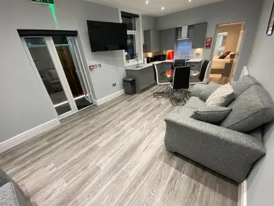 a living room with a couch and a kitchen at Edward Place Luxury Hot Tub Apartments in Blackpool