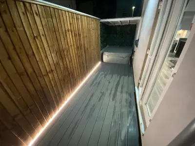 an outdoor deck with a bench and a wooden fence at Edward Place Luxury Hot Tub Apartments in Blackpool
