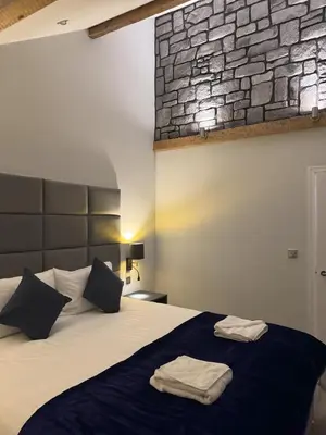 a bedroom with a bed with two towels on it at Edward Place Luxury Hot Tub Apartments in Blackpool