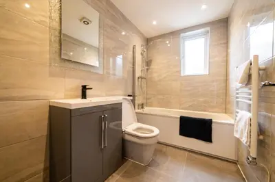 a bathroom with a toilet and a tub and a sink at Hollywood Suite Sasco Apartments in Blackpool