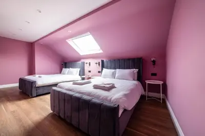 two beds in a room with purple walls at Hollywood Suite Sasco Apartments in Blackpool