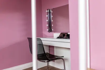 a black chair sitting in front of a desk with a mirror at Hollywood Suite Sasco Apartments in Blackpool