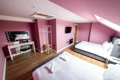 a bedroom with purple walls and a bed and a desk at Hollywood Suite Sasco Apartments in Blackpool