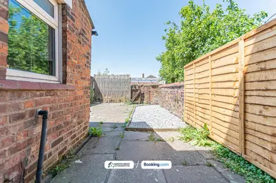 a brick fence next to a sidewalk next to a building at Modern 3BR House in Ince Ideal for Contractors & Long Stays in Pemberton