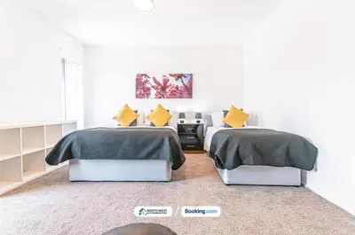 two beds in a white room with yellow pillows at Modern 3BR House in Ince Ideal for Contractors & Long Stays in Pemberton